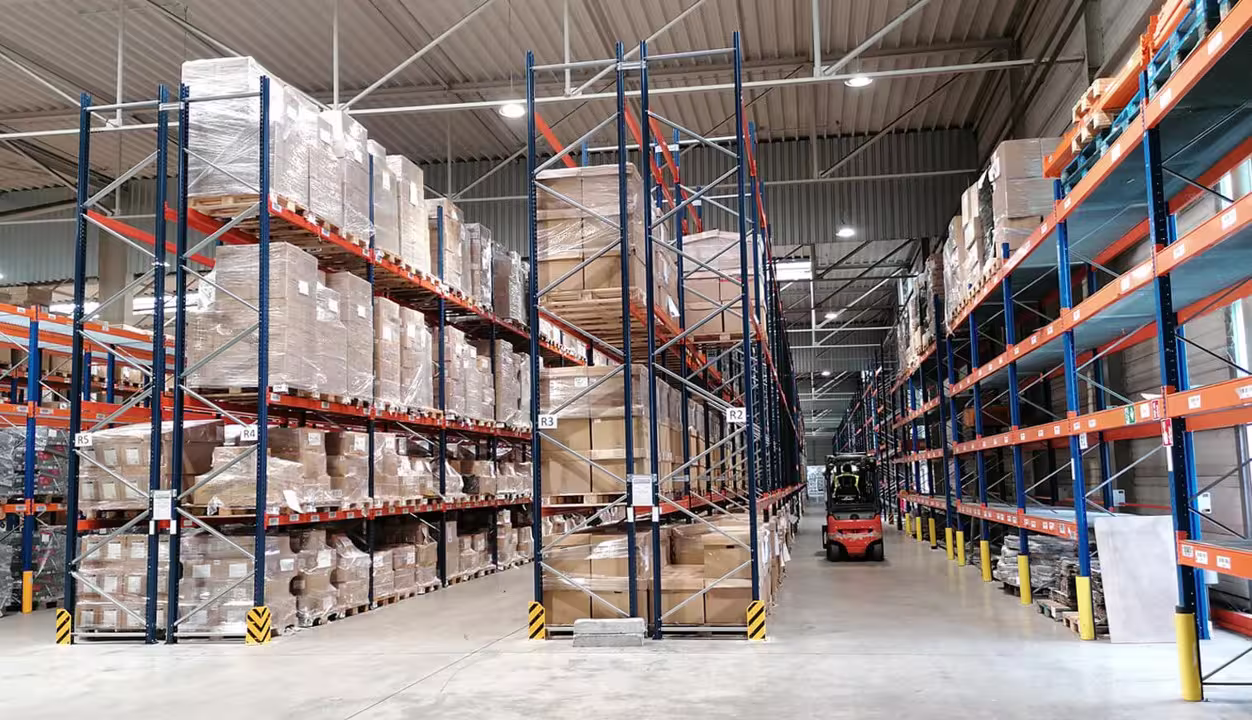 Almacen industrial con estanterias y carretillas en movimiento